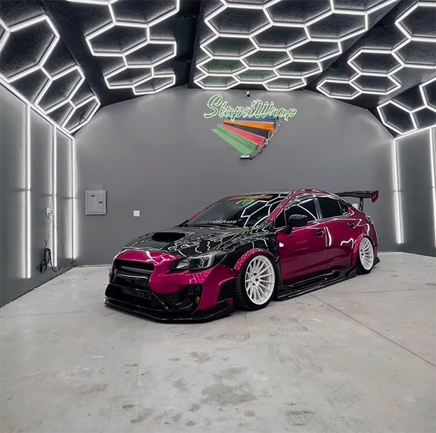 Technician applying a color change vehicle wrap on a car